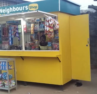 Woman entrepreneur inside of a Neighbours Shop solar-powered kiosk in Lagos.