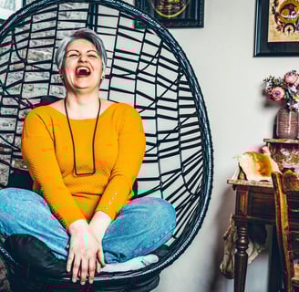a woman sitting in a chair with a smile on her face
