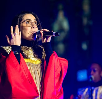 une femme en robe rouge et lunettes chantant du gospel