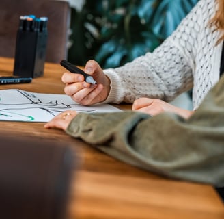 une femme est assise à une table montrant un dessin à son associée