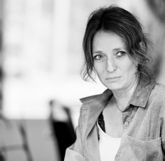 a woman sitting at a table with a cup of coffee