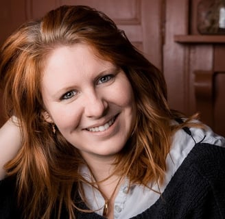 a woman with red hair and a black sweater