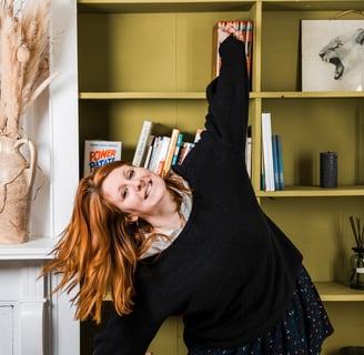 Femme rousse prenant une pose naturelle dans une bibliothèque
