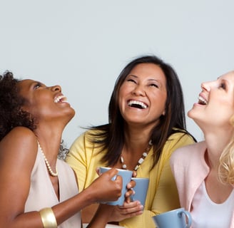 three women sitting on a couch and laughing