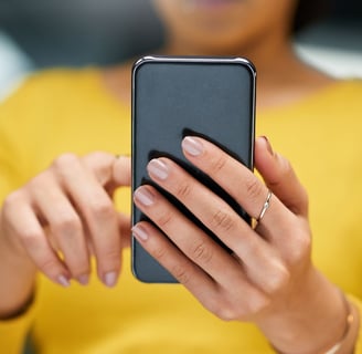 a woman in a yellow shirt is holding a cell phone