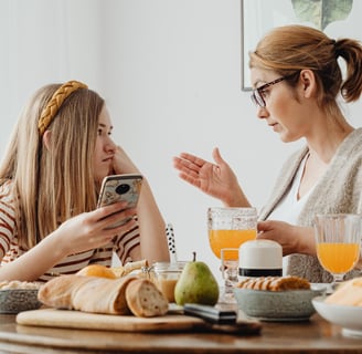 a woman sitting at a table with her child