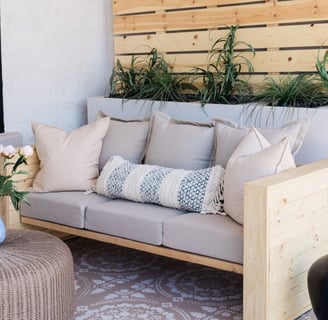 a couch with pillows and pillows on a patio