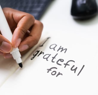 a person writing on a notepad with a pen