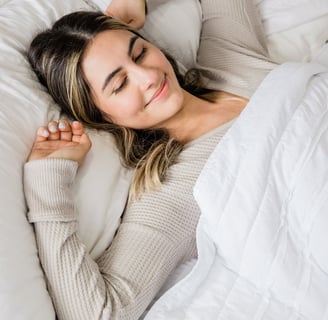 a woman laying on a bed with her eyes closed