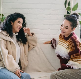 two women sitting on a couch in a living room