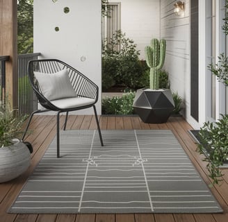 A black metal chair with a white cushion, a geometric planter with a single cactus, and a clean-line