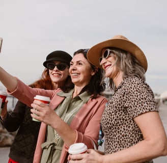 three women taking a selfie with a coffee cup