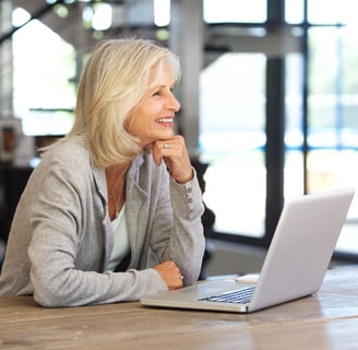 a woman sitting at a table with a laptop