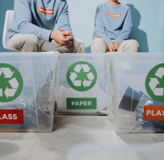 two people sitting on a table with plastic containers