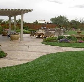 A vibrant garden landscape features lush green and red foliage. In the foreground, there is a structure covered with netting