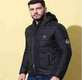 a man in a black jacket and jeans standing in front of a yellow wall