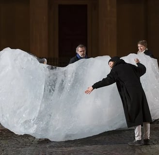 Olafur Eliasson "Ice Watch" a man and woman standing in front of a large piece of ice
