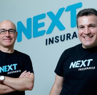 next insurance two men standing next to each other in front of a next - to - sign