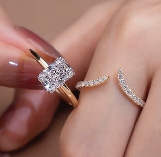 The image features two elegant rings worn on a woman’s fingers, showcasing a modern and luxurious je