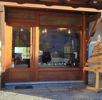 ingresso e vetrina del negozio di Sampeyre della Mieleria Garnero, con insegna e ape di legno
