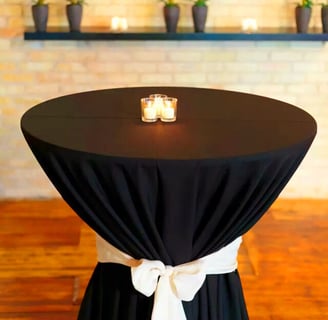 Mesa de coctel decorada con un mantel obscuro