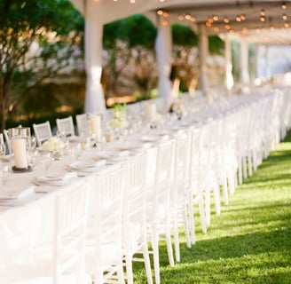 a long table with white chairs and tables