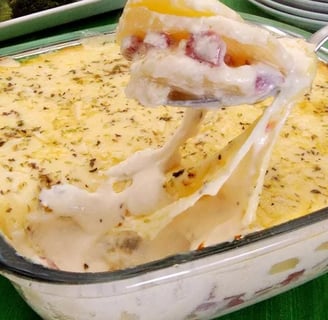 Imagem-de-um-refratário-de-cerâmica-com-batata-gratinada-quente-e-cremosa. A batata está cortada em 