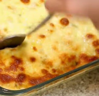   Imagem de um arroz de forno com mussarela, com uma textura cremosa e derretida. O arroz está num r