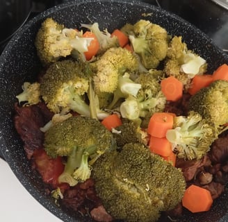 Foto de uma frigideira com fraldinha picada em cubos, cenoura picada, cebola e brócolis ninja.