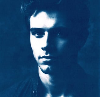 Close-up portrait of a young man with a strong jawline and high cheekbones, featuring dramatic light