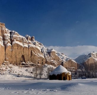 Bamiyan snowy winter landscape with an Muslim tomb and the Buddha niche in the background