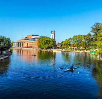 a photo of the Royal Shakespeare Theatre at Stratford Upon Avon with the river Avon in the foreground