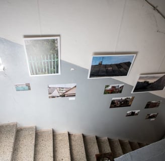 Paintings in the corridor above the stairs. Photos are hung and stuck as stickers. 