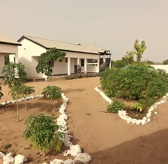 De Morgan Kunda Lodge, genesteld in een schilderachtige natuurlijke omgeving, met traditionele riete