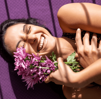 Chica sonriente y feliz con flores violetas