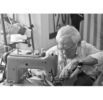 Pensionado trabajando en maquina de coser.