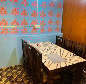 a table with a tablecloth and chairs in Sarpanch Restaurant Bareilly Fatehganj