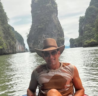 Travel writer Rick Silvia kayaks in Kong Bay with gigantic limestones in the background