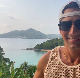 Rick Silvia stands infant of a stunning background; hidden beach with turquoise waters and mountains