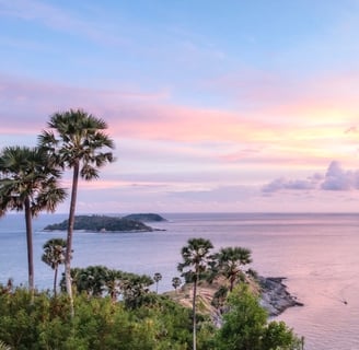 a lookout view from Phuket Thailand with Palm trees and islands at sunset