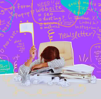 A woman sits with her head down on a cluttered desk, surrounded by crumpled paper balls. She holds up a white flag.