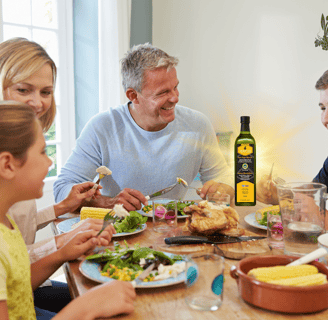 a happy family sitting at a table with a meal