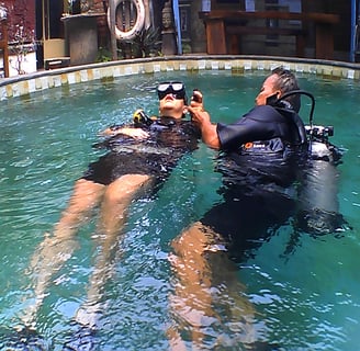 a man and woman in scuba gear in a pool for rescues dive course