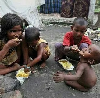 a group of children eating food in a makeshift shelter in Africa