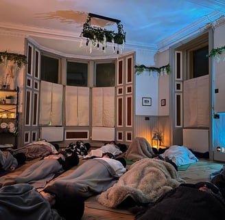 a group of people laying on floor with blankets enjoying a sound bath