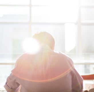 a person sitting at a table with a laptop