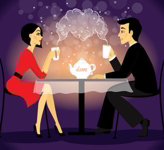 a man and woman sitting at a table with a teapot