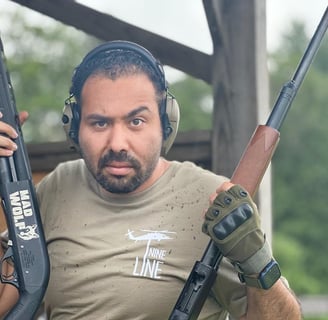 a man in a tan shirt holding two guns