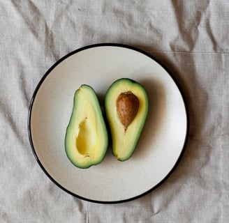 Abacate cortado em um prato para lembrar que as frutas não engordam se consumidas com moderação