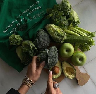 Pessoa cortando frutas e legumes mostrando qual é a dieta ideal para ter uma vida saudável 
